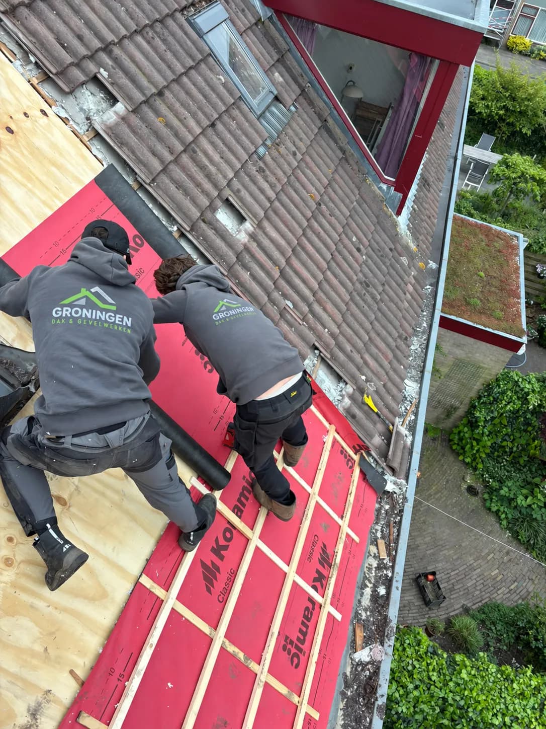 Werk aan een opengemaakt pannendak met zichtbaar hout en dakfolie.